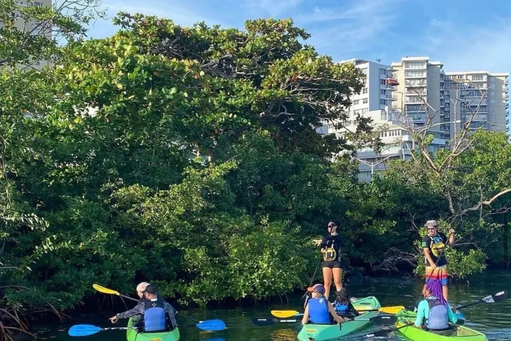 a group of people riding on the back of a boat in the water