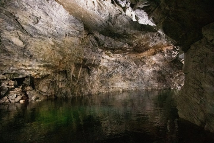 Rocky cave interior with water reflecting the cave walls.
